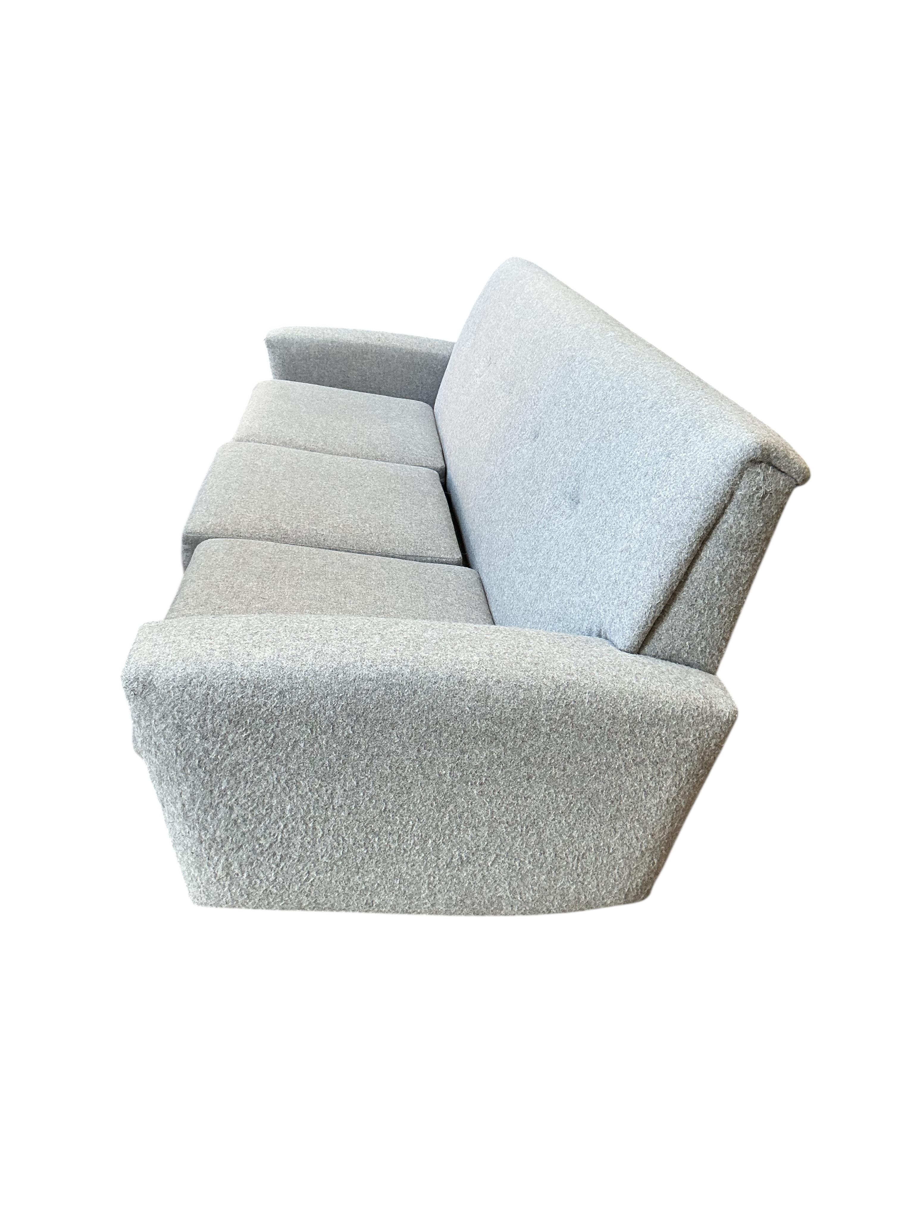 In the manner of Georg Thams, a Danish style mid century design three seater settee upholstered in grey wool fabric, width 214cm, depth 68cm, height 73cm